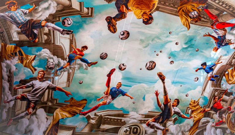 Marouflage (Deckengemälde) mit Fußballszenen während der FIFA Fussball-Weltmeisterschaft 2006 im Kölner Hauptbahnhof. Auf einer Fläche von mehr als 800 Quadratmetern hat Adidas ein Fresko an der Decke des Kölner Hauptbahnhofs anbringen lassen. In originalgetreuer antiker Anmutung schweben Nationalspieler wie Michael Ballack, David Beckham, Zinédine Zidane und Juan Román Riquelme hoch über den Köpfen der Passanten / © Foto: Georg Berg