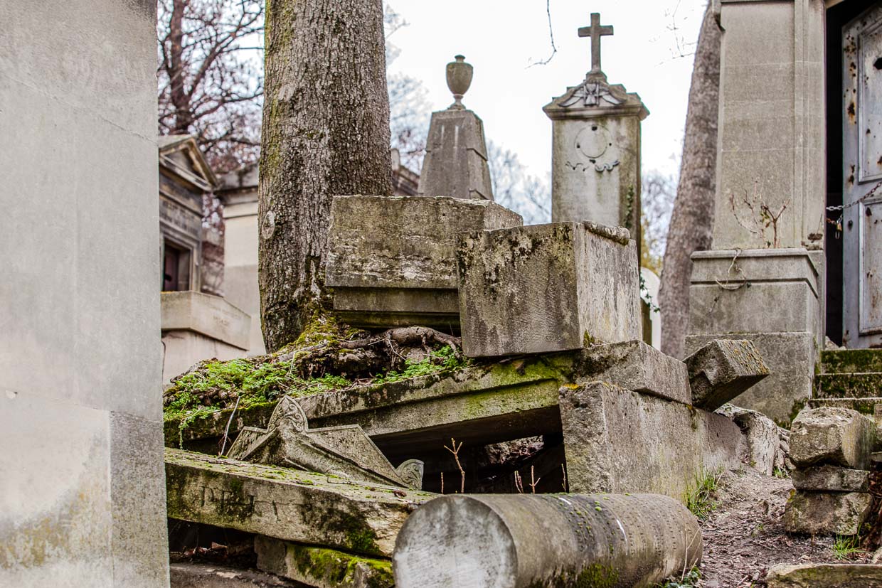 Grab mit von Baumwurzeln gesprengten Steinplatten auf dem Friedhof Père-Lachaise / © Foto: Georg Berg