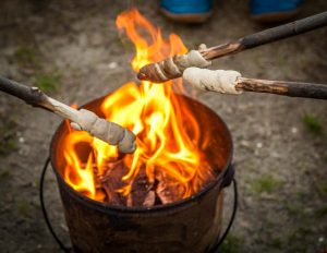 Stockbrot wird auf einem Campingplatz über einem Feuereimer gebacken
 / © Foto: Georg Berg