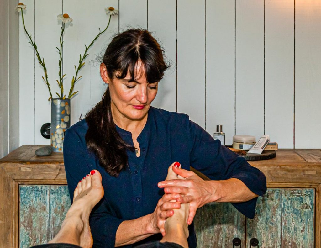 Mit viel Zeit erspürt Gwenn Libouban Schwachstellen im Körper. Eine Stunde dauert die erste Fußrefexzonen-Massage, die schon als Therapie wirkt / © Foto: Georg Berg