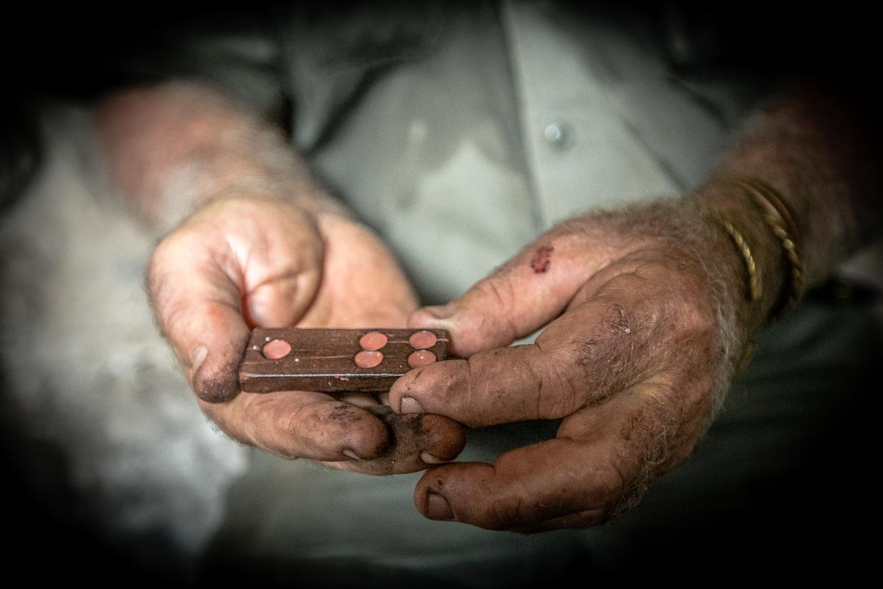 Sab Lord hält einen Dominostein in der Hand, der in einer Aborigine-Höhle hinterlegt worden ist / © Foto: Georg Berg