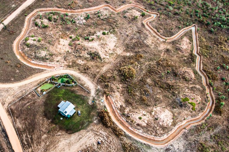 Unter den Kufen des Helikopters eine im Bau befindliche Ferienanlage im Grundriss Australiens / © Foto: Georg Berg
