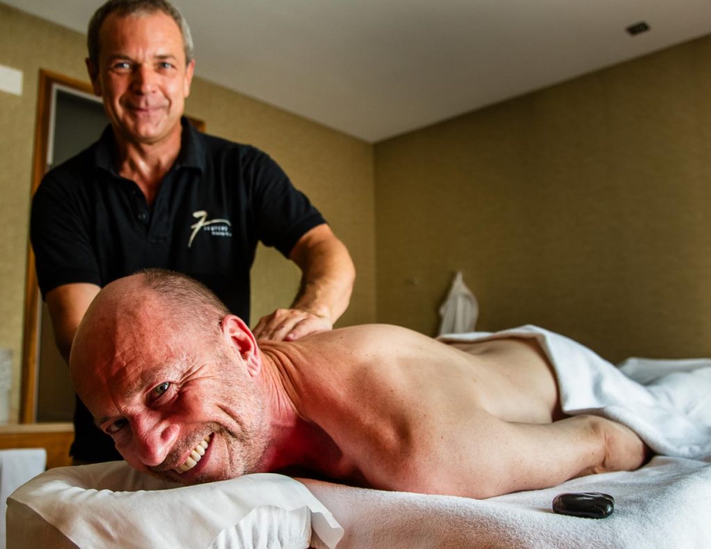 Georg Berg freut sich über eine entspannende Massage, bei der auch heiße Kieselsteine aus dem Flussbett der Simme zum Einsatz kommen / © Foto: Moritz Berg