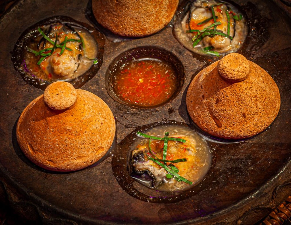 Zugedeckt mit konischen Keramik-Deckeln kommen die heißen Hanuman Oysters auf den Tisch / © Foto: Georg Berg