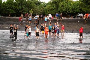 Kinder winken am Strand im ländlichen Indonesien / © Foto: Georg Berg