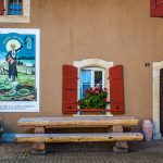Absinth in Frankreich und der Schweiz. In Motiers im Schweizer Kanton Neuchâtel befindet sich das unterhaltsame Absinthmuseum, und an einigen Häuserwänden der Stadt erinnern historische Plakate an die Zeit der Prohibition / © Foto: Georg Berg