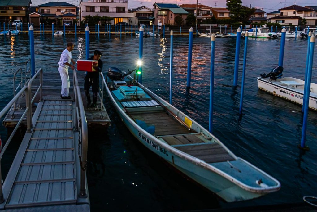 Die Sonne geht gerade unter am Hamana See. Zeit, das Boot mit dem Fischerei-Werkzeug und der Kühlbox für den Fang von Fischen und Krebsen zu beladen / © Foto: Georg Berg