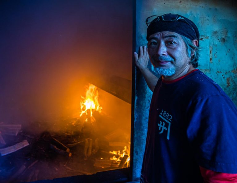 Yasuhisa Serizawa vor dem begehbaren Räucherofen seiner Katsuobushi Manufaktur. Er wendet die älteste Methode der Fischkonservierung an und produziert damit eine Delikatesse / © Foto: Georg Berg