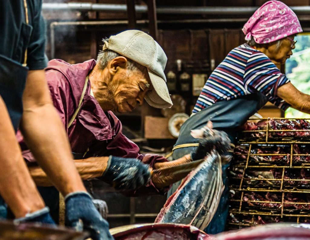 Mit weit über 80 Jahren ist Herr Serizawa noch im Einsatz. Hier beim Zerlegen von Fisch. Namagiri heisst dieser Arbeitsschritt, bei dem die kleine Thunfischart Bonito geteilt und die Innereien entfernt werden / © Foto: Georg Berg