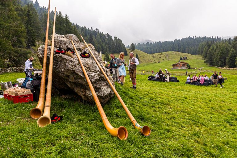 Alphörner gehören zur zünftigen Folklore beim Gourmet-Event auf der Gompm-Alm in Südtirol. Es findet jedes Jahr am letzten Sonntag im August statt. Bekannte Köche bereiten ihre Gerichte auf alten Holzöfen zu / © Foto: Georg Berg