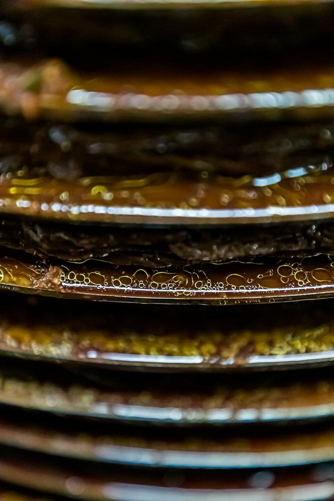 In den traditionellen Ölmühlen sind die Arbeitsschritte auf dem Weg zum Olivenöl noch einsehbar. Hier erkennt man Öl und Fruchtwasser, das aus der Presse herausläuft und aufgefangen wird,  Draguignan, Department Var, Provence, Frankreich / © Foto: Georg Berg