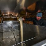 Hausbrauer Wolfgang Üblacker füllt zuerst flüssige Hefe in den Tank, damit sie sich gut mit der Bier-Würze mischt / © Foto: Georg Berg