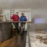 Kurz bevor sich das Brauhaus mit dichtem Nebel füllt steht Zoigl-Braumeister Sepp Neuber mit einem Hausbrauer am Schiff / © Foto: Georg Berg