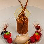 Die wunderschönen Desserts wie dieser Schockokuchen mit Timut Pfeffer an Tonka Eis werden von Florent Jestin dekoriert / © Foto: Georg Berg