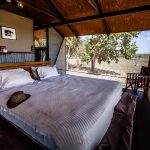 Doppelbett im australischen Outback-Chic hinter den Wellblechwänden der Bamurru Plains Lodge. Wind weht durch die Fliegengitter und keiner vermisst Klimaanlage oder WLAN / © Foto: Georg Berg