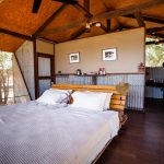 Doppelbett im australischen Outback-Chic hinter den Wellblechwänden der Bamurru Plains Lodge. Wind weht durch die Fliegengitter und keiner vermisst Klimaanlage oder WLAN / © Foto: Georg Berg