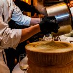 Ein ausgehöhlter Parmesanlaib wird mit Risotto gefüllt / © Foto: Georg Berg