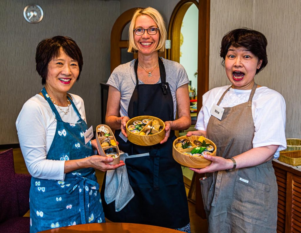 Nach erfolgreicher Dekorationsarbeit präsentieren Kayoko Kawamuar, Reporterin Angela Berg und Noriko Hasegawa von Cooking Holiday Izu ihre Bento Boxen / © Foto: Georg Berg