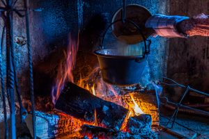 In Cerentino kann man im aufwendig renovierten historischen Patrizierhaus Cà Vegia wohnen, mit jahrhundertealten Originalmöbeln, aber ohne Strom. Polenta wird über dem offenen Feuer zubereitet, Circolo della Rovana, Schweiz / © Foto: Georg Berg