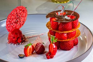 Dessert aus Mara des Bois Erdbeeren. Ein dreigeschossiges Erdbeerdessert mit Etagenböden aus Krokant-Chips und einem Erdbeer-Sorbet auf Rhabarber-Vervene-Mousse verziert mit einem Erdbeer-Algen Chips mag man gar nicht mit seinem Löffel unterwandern, so schön ist es anzusehen / © Foto: Georg Berg