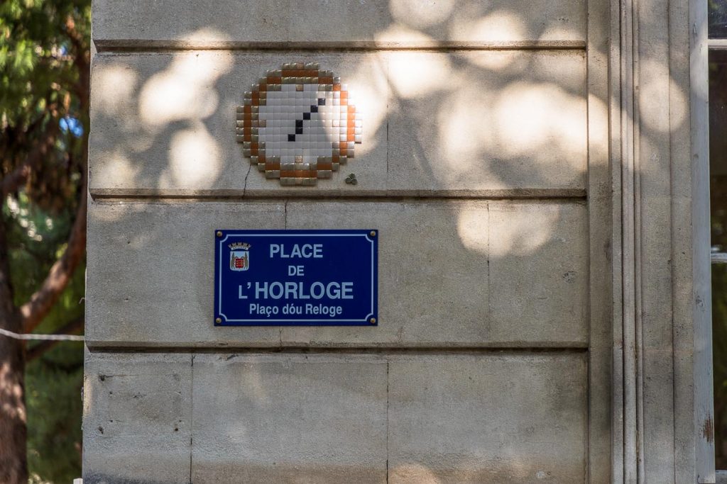 MifaMosa Place de L'Horloge, Avignon, Frankreich. Der französische Künstler peppt Straßenschilder in verschiedenen Städten mit Mosaiken auf, die Bezug zum Straßennamen haben. Als besonderes Kennzeichen sind bei jedem Bild drei Punkte aufgeklebt, die ihn selbst, seine Mutter und seine Schwester symbolisieren / © Foto: Georg Berg