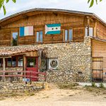 Die Schokoladen-Manufaktur Frigoulette liegt im Dorf Beaufort-sur-Gervanne mitten im Naturpark Vercors. Eine kurvige Straße führt aus dem Dorf heraus Richtung Frigoulette. Die Manufaktur ist nach dem Land benannt, auf dem die Familie von Bernard Xueref seit Generationen Landwirtschaft betreibt. Über dem Eingang des Holzbaus hängen die Flaggen von Frankreich und São Tomé & Principe / © Foto: Georg Berg