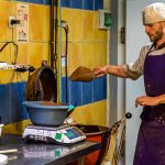 Ein Mitarbeiter der Chocolaterie Frigoulette wiegt Zutaten für die berühmte Malakoff-Praline ab. Bei Frigoulette werden keine tierischen Fette wie Milch, Sahne oder Butter verarbeitet. Auch Palmöl kommt nicht zum Einsatz. Stattdessen 68 prozentiger Kakaoanteil und echte Kakaobutter aus São Tomé / © Foto: Georg Berg