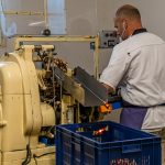 Maschinelle Verpackung von Nuss-Nougat-Pralinen in gold und rot gesteiften Papilloten in der Chocolaterie Frigoulette in Beaufort-sur-Gervanne im Val de Drôme / © Foto: Georg Berg