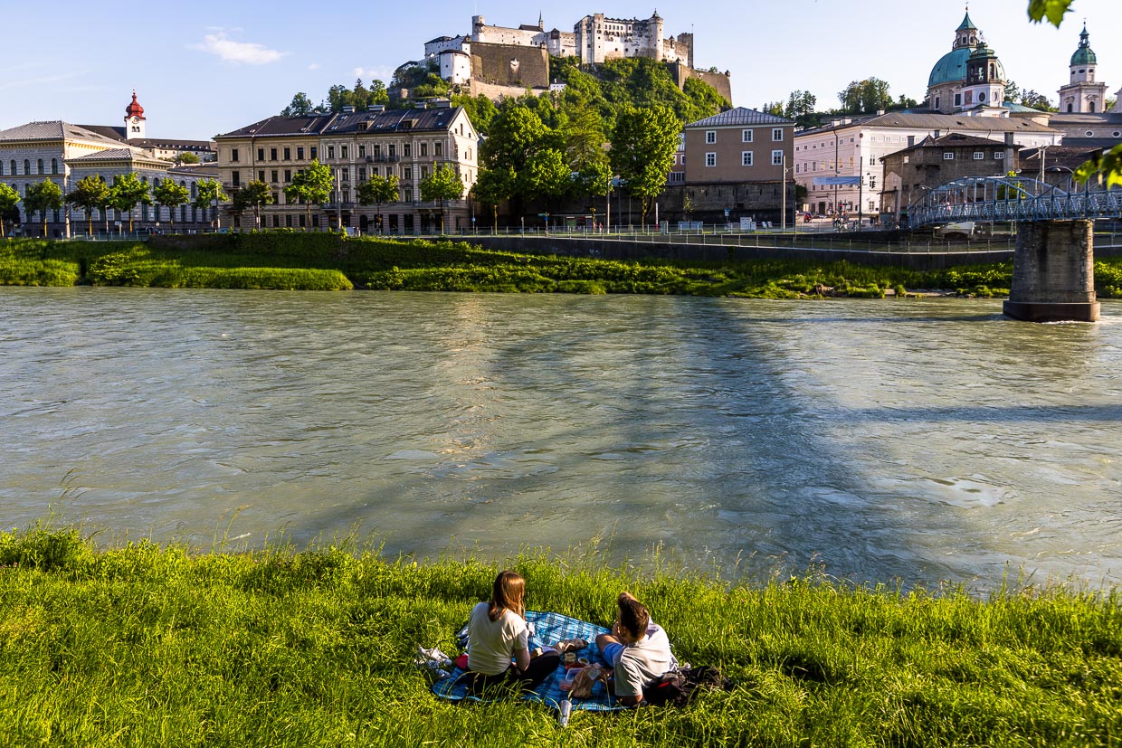 Das Ufer der Salzach mit Blick auf Festung und Dom-Quatier ist ein beliebter Picknickplatz für Paare in Salzburg / © Foto: Georg Berg