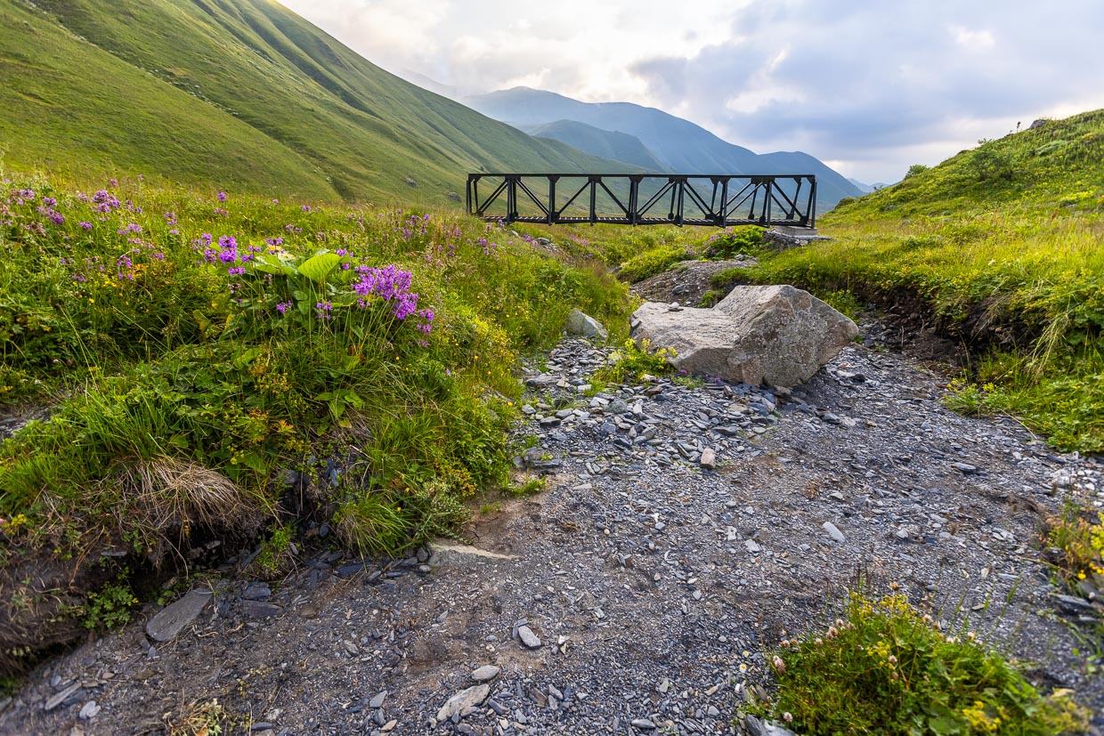 Brücke, die man nicht braucht. Sie führt über ein Fussbett. An der Vegetation erkennt man aber, dass der Fluss im Sommer noch nie Wasser geführt hat / © Foto: Georg Berg