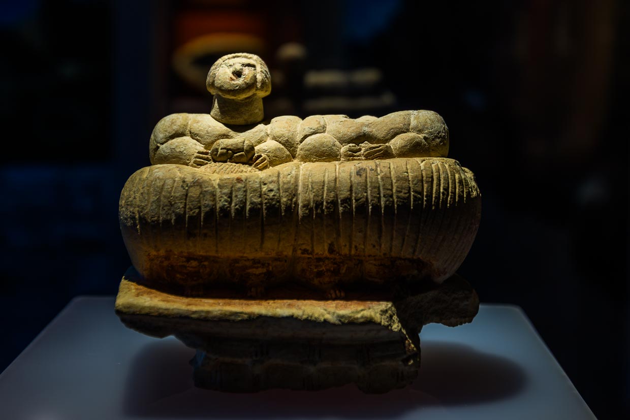 Eine Skulptur, die zwei korpulente Menschen, die auf einem Korbsofa sitzen, darstellt, ist einzigartig auf Malta und unterscheidet sich auch von anderen mediterranen Skulpturformen. Sie haben ungleiche Zopffrisuren. Der erhaltene Kopf trägt einen aufwendigen Haarknoten mit herabhängendem Zopf. Die eine Figur trägt in der Hand eine kleinere Darstellung ihrer selbst, die andere ein kleines Gefäß.Die Ġgantija-Tempel auf der Insel Gozo gehören zur UNESCO Welterbestätte Megalithische Tempel von Malta und den ältesten noch halbwegs erhaltenen freistehenden Gebäuden der Welt / © Foto: Georg Berg