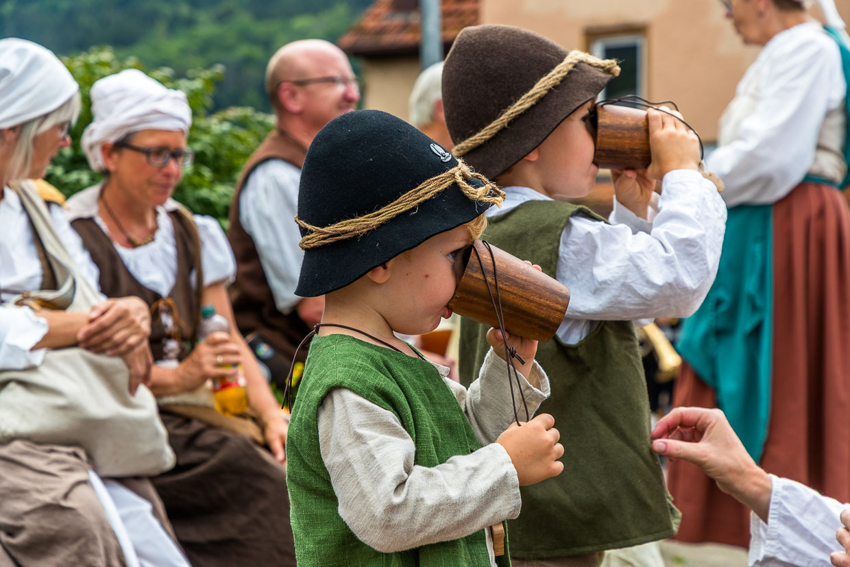 Deux petits garçons d'un groupe folklorique boivent dans des gobelets en bois, 300 ans de course des bergers à Wildberg, Forêt-Noire / © Photo : Georg Berg
