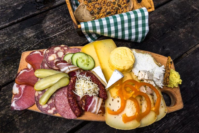 Jausenplatte auf der Filzmoosalm. Sauerkäse, Camenbert, Butter, Schnittkäse, Speck, Schinken und Wurst mit Brot stammen aus eigener Herstellung / © Foto: Georg Berg