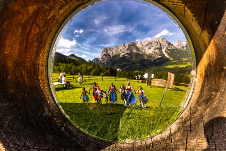 Die perfekte Illusion für „The Sound of Music-Fans. Der Blick auf Burg Hohenwerfen durch das Gucklock ist genauso real wie die anderen Besucher am Ziel des Sound of Music-Trails. Nur Julie Andrews tanzend mit den Trapp-Kindern ist in die Szenerie gestanzt / © Foto: Georg Berg