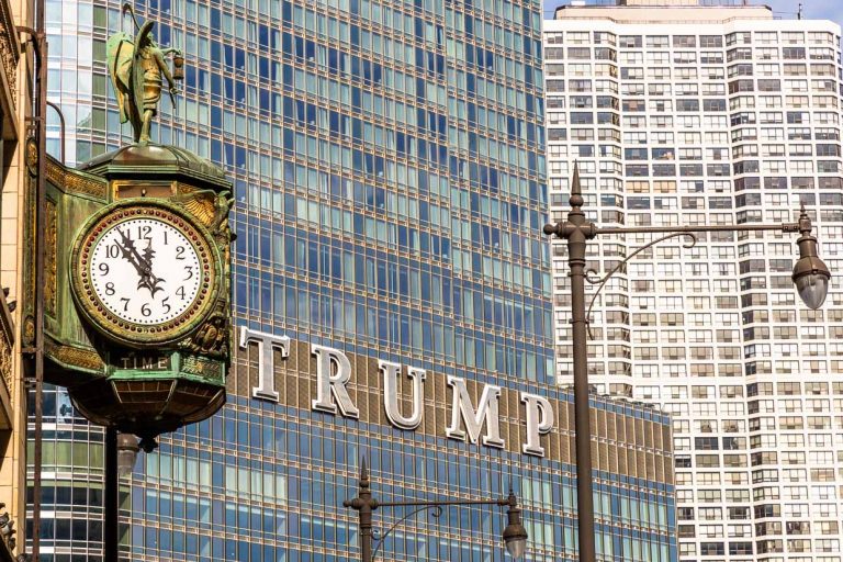 Trump Tower Chicago an der DuSable Bridge und gegenüber eine alte Straßenuhr mit der Zeitanzeige „Fünf vor zwölf“ / © Foto: Georg Berg