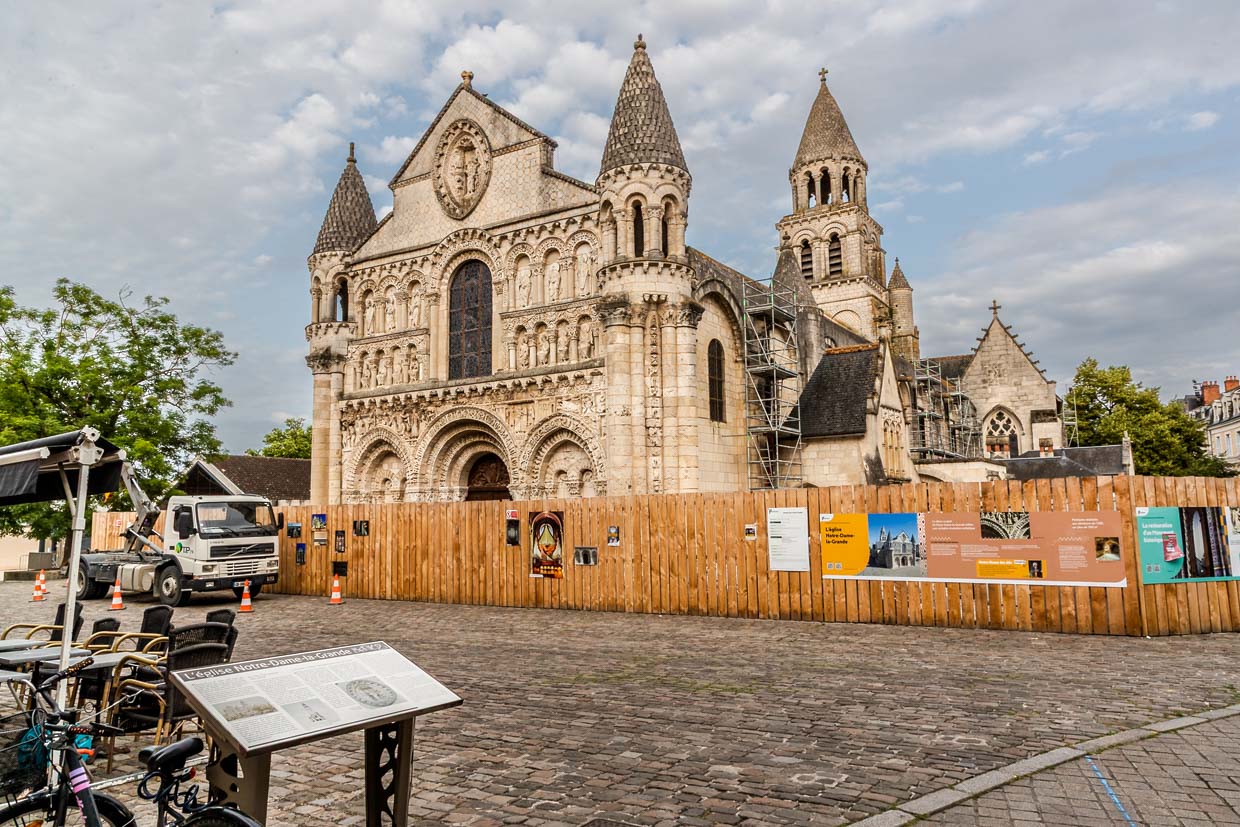 Die Kirche Notre-Dame-la-Grande in Poitiers ist ein Meisterwerk der romanischen Architektur. Ihre Geschichte reicht bis ins 10. Jahrhundert zurück, In den Jahren von etwa 1115 bis 1130 wurde die Kirche nach Westen erweitert; ihre prachtvolle, heute berühmte Westfassade stammt aus dieser Zeit. 2025 ist sie wegen umfangreicher Renovierung von einem Bauzaun umgeben / © Foto: Georg Berg