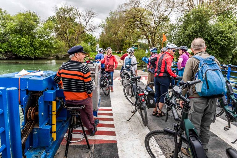Eine Gruppe von Radfahrern überquert die Charente per Fähre / © Foto: Georg Berg