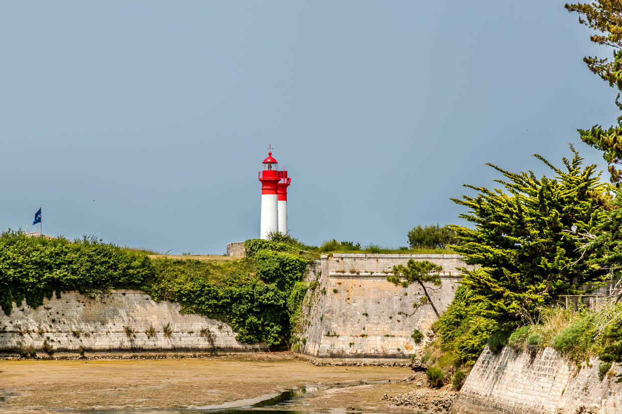 Fortification wall of the island of Aix with the island's two lighthouses. The lighthouses were used to navigate ships safely through the shallow and sometimes dangerous waters around the island. As the approach to the Rochefort naval arsenal had to be well protected and controlled, several strategic lighthouses were set up / © Photo: Georg Berg