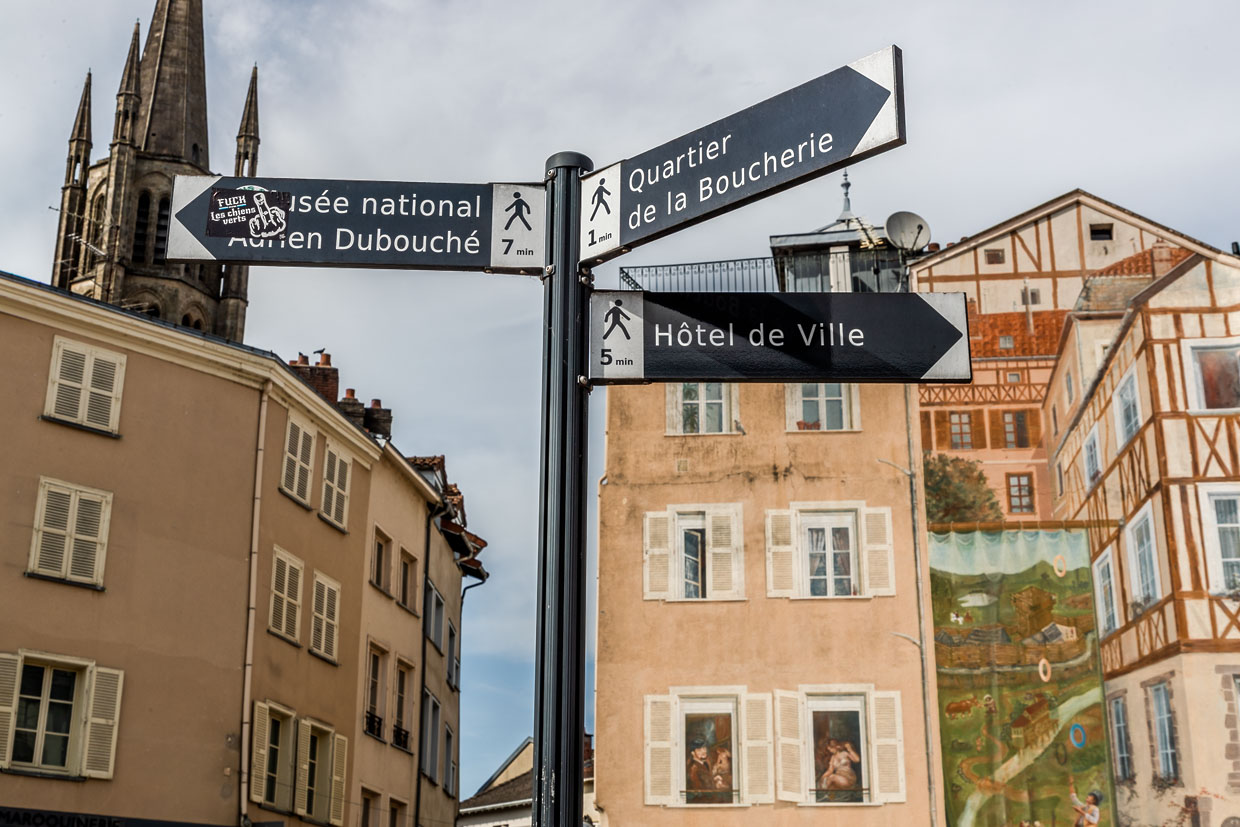 Signs in the center of Limoges pointing to the city's sights, such as the Musée National Adrien Dubouché, the butcher's quarter and the town hall, in the background a mural painting, in the style of the old half-timbered houses / © Photo: Georg Berg