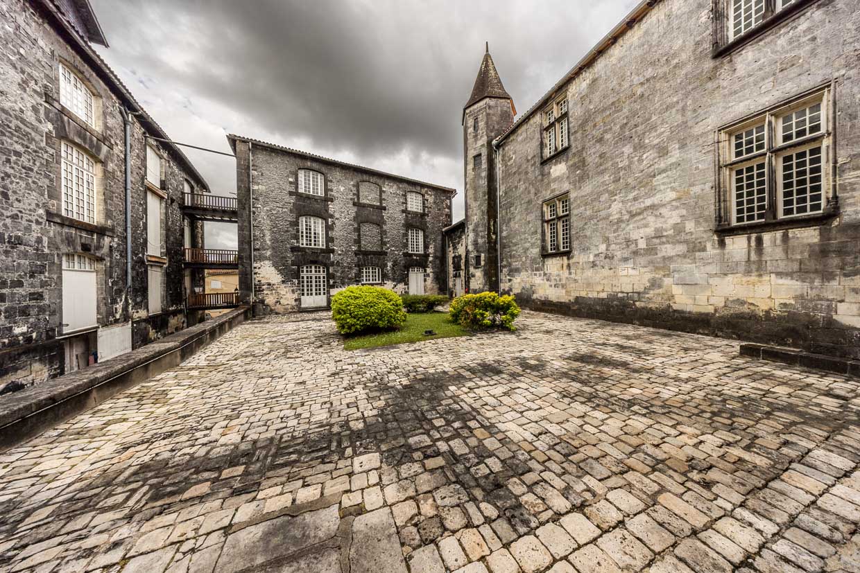 Cognac Castle courtyard. The black fungus is so characteristic of Cognac that even the white limestone facades of the town and the maturing cellars (