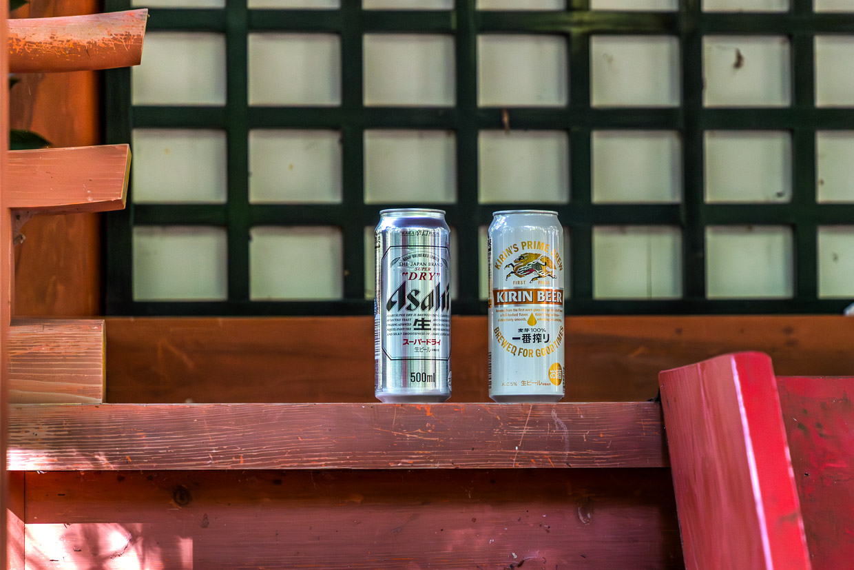 Zwei Bierdosen am Hosshinmon-oji. Die Bierdosen sind eine Opfergabe und nicht, wie man meinen könnte, achtlos abgestellter Müll. Der kleine Schrein mit einem Tor markiert den äußersten Eingang zum heiligen Bezirk des großen Schreins Kumano Hongu Taisha / © Foto: Georg Berg