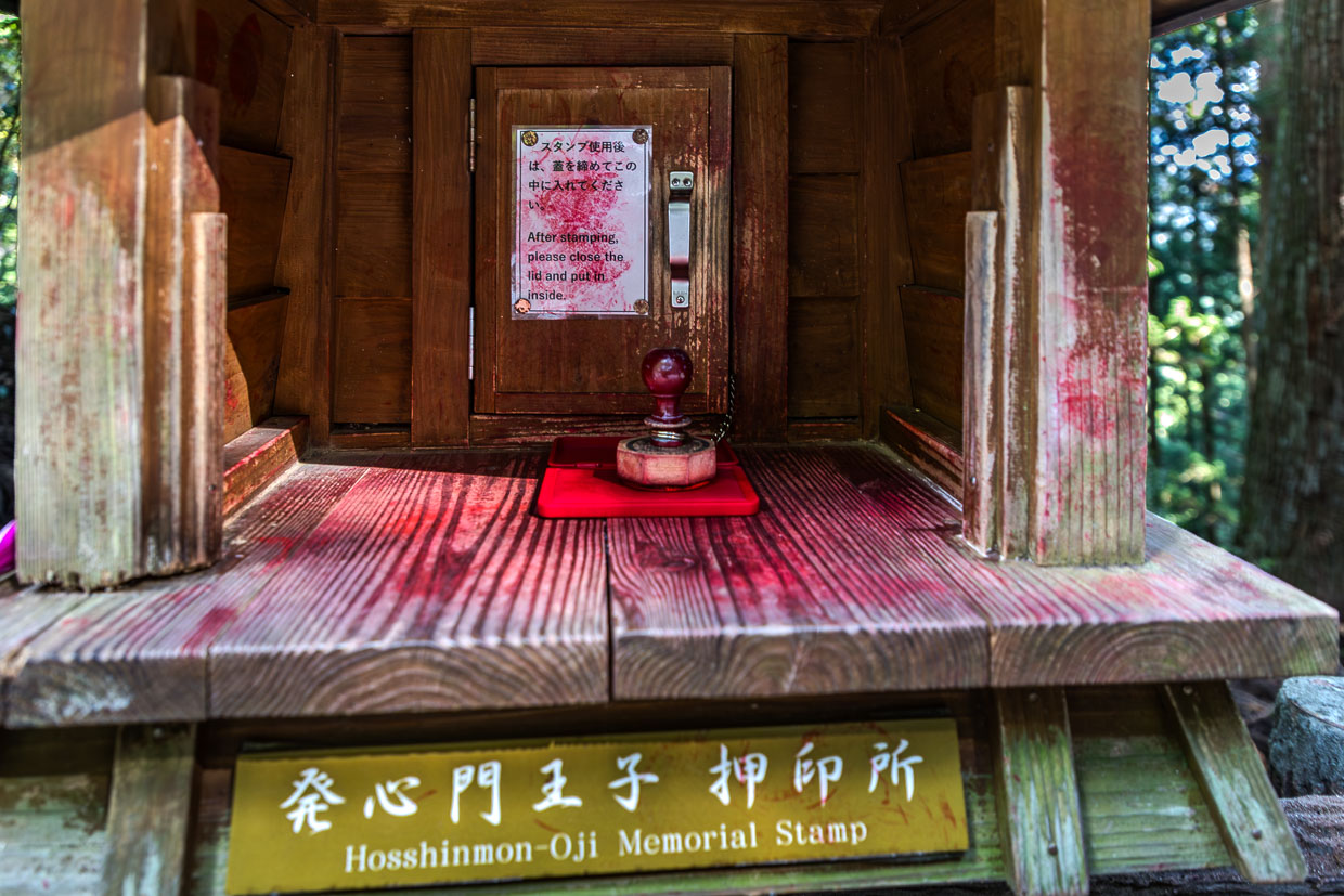 Stempelbox am Hosshinmon-oji. Die Stempel werden mit roter Tinte in einem Pilgerbuch (Nōkyōcho) gesammelt und dokumentieren den Fortschritt zu den Kumano Sanzan und 99 Oji-Schreinen. Sie symbolisieren Reinigung, Hingabe und Erreichen heiliger Orte – ähnlich wie der Jakobsweg nach Santiago de Compostela / © Foto: Georg Berg