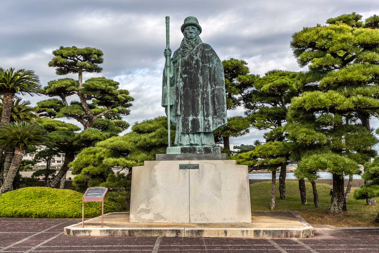 Bronzestatue eines Mannes mit Hut und Stab steht auf einem Sockel in Toba, Japan