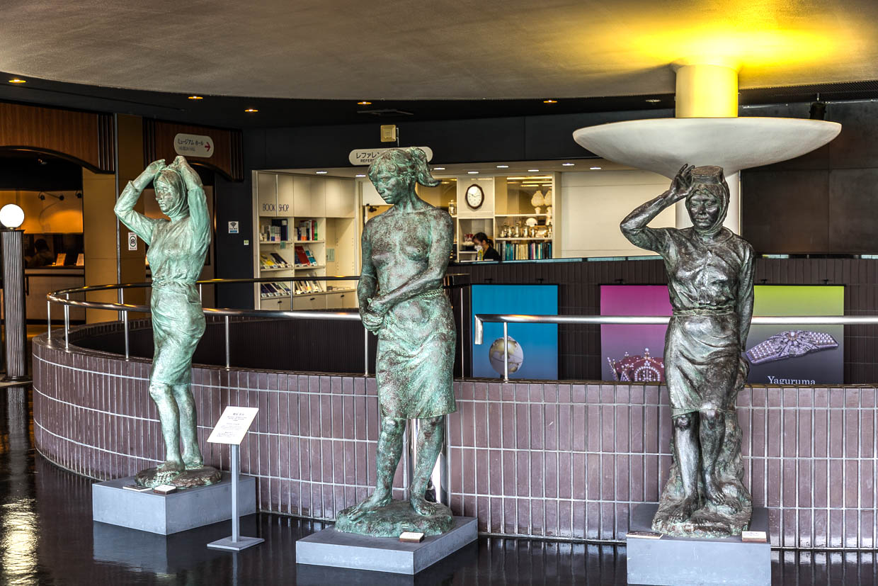 Drei Bronzestatuen von Frauen stehen in einem Museum in Toba, Japan