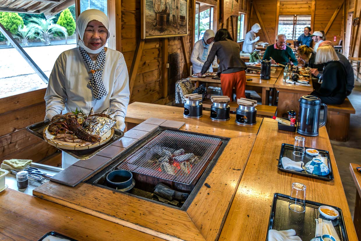 Köchin präsentiert Hummer und Fisch auf einem Tablett in Shima, Japan