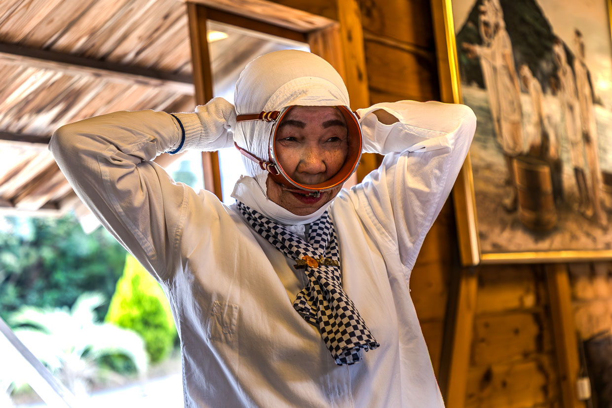 Ältere Frau mit traditioneller Kleidung und Maske in Shima, Japan