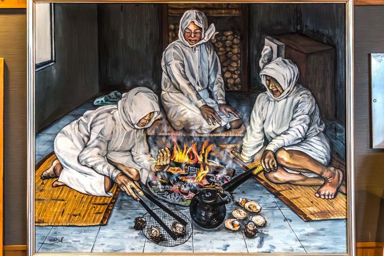 Drei Frauen bereiten Meeresfrüchte über einem Feuer in Shima, Japan zu