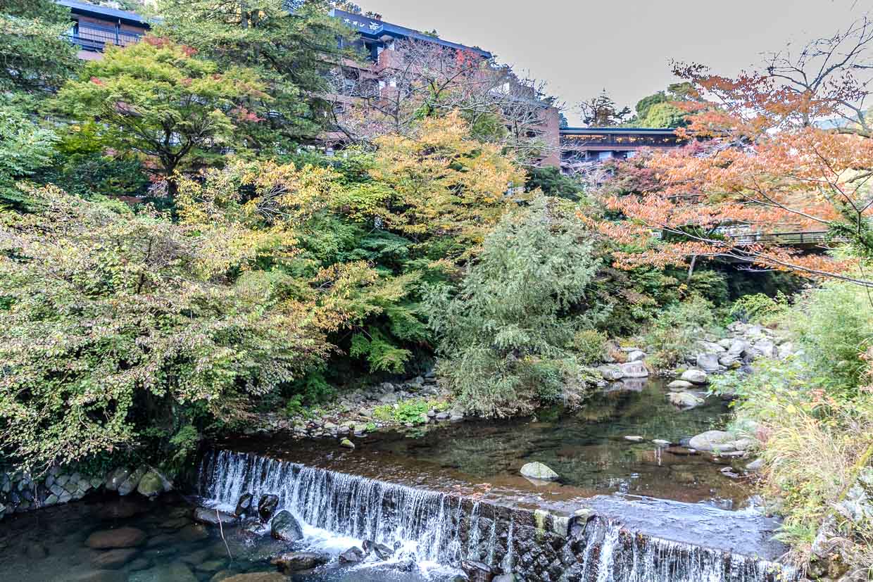 Herbstlaub umgibt einen kleinen Wasserfall am 滝通り, Hakone, Japan