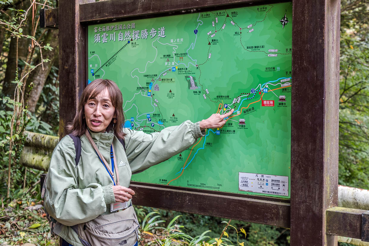 Frau zeigt auf eine Wanderkarte am 湯本元箱根線, Hakone, Japan