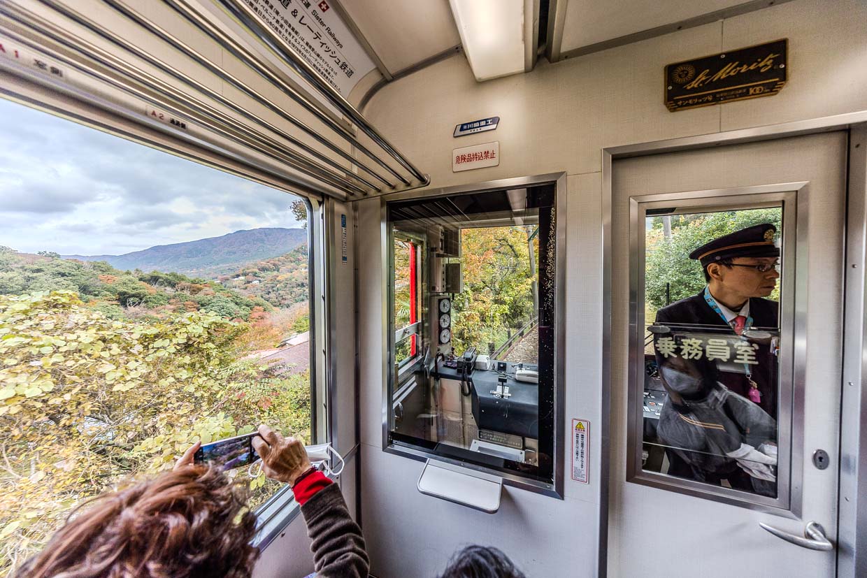 Fahrgast fotografiert Landschaft aus fahrendem Zug in Hakone, Japan